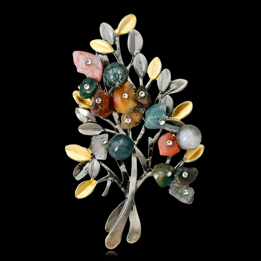 colored stone christmas tree brooch on a black background