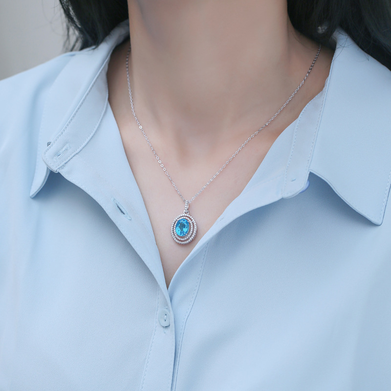 Model wearing a silver necklace with a topaz pendant