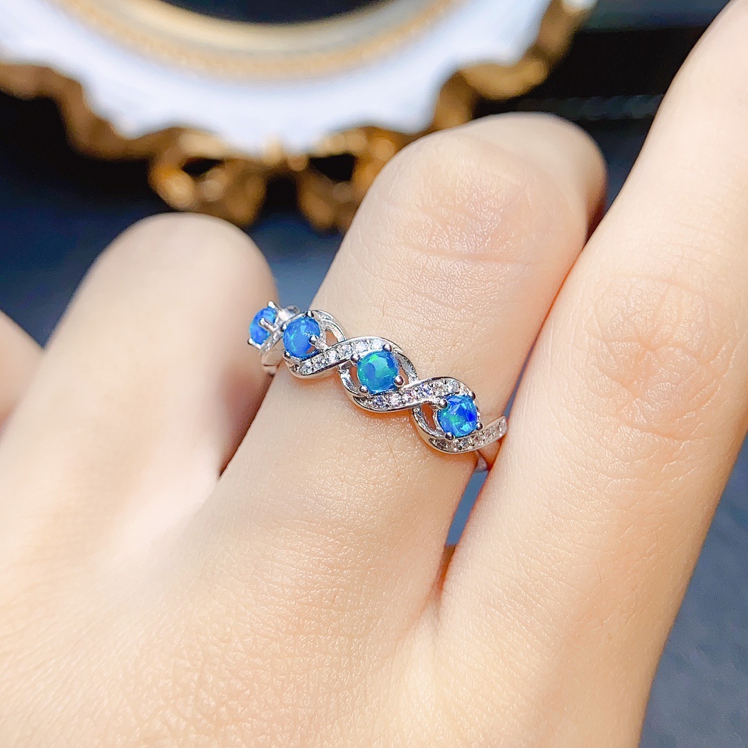 Woman showcasing a blue opal adorned ring